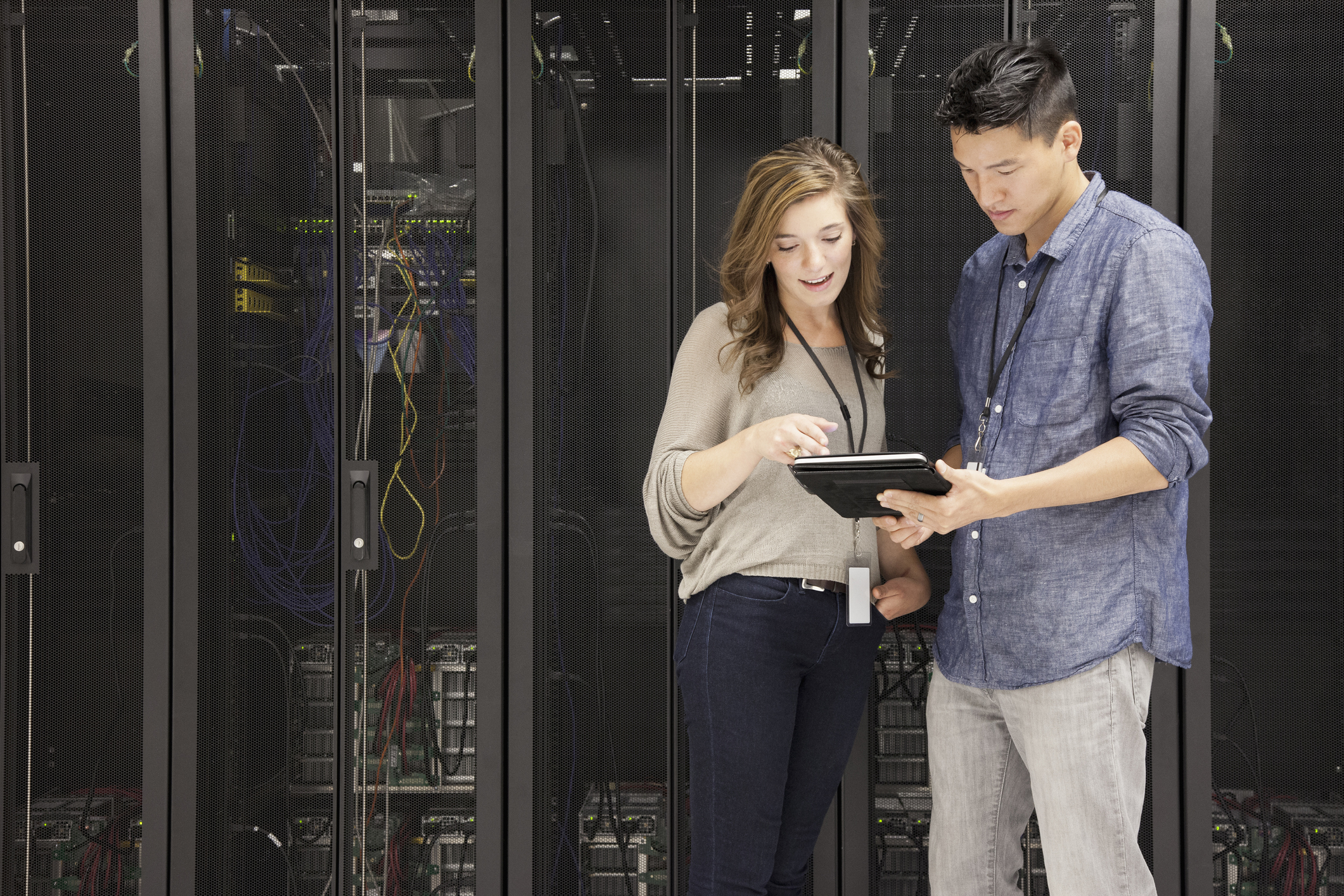 Business people using tablet computer in server room