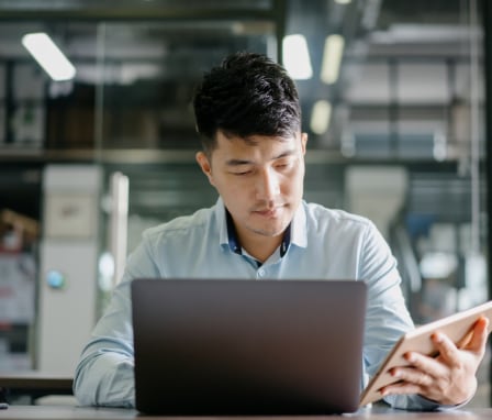 Man working on laptop and tablet