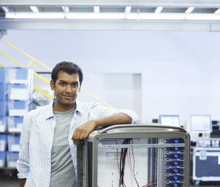 Man leaning on server in server room