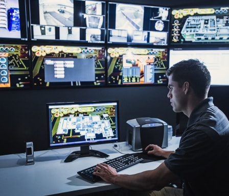 Man looking at multiple computer monitors