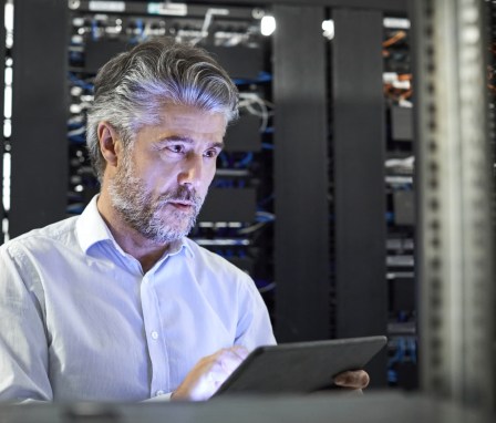 Man on tablet in server room