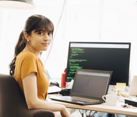 Woman coding on a computer at a desk