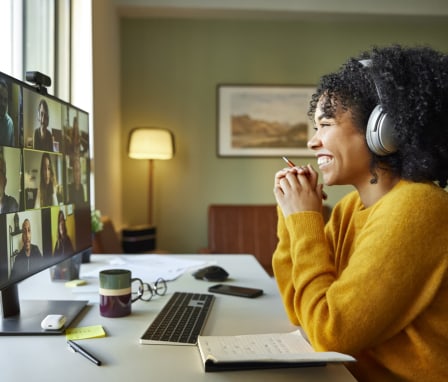 Woman smiling on a group video call on her computer